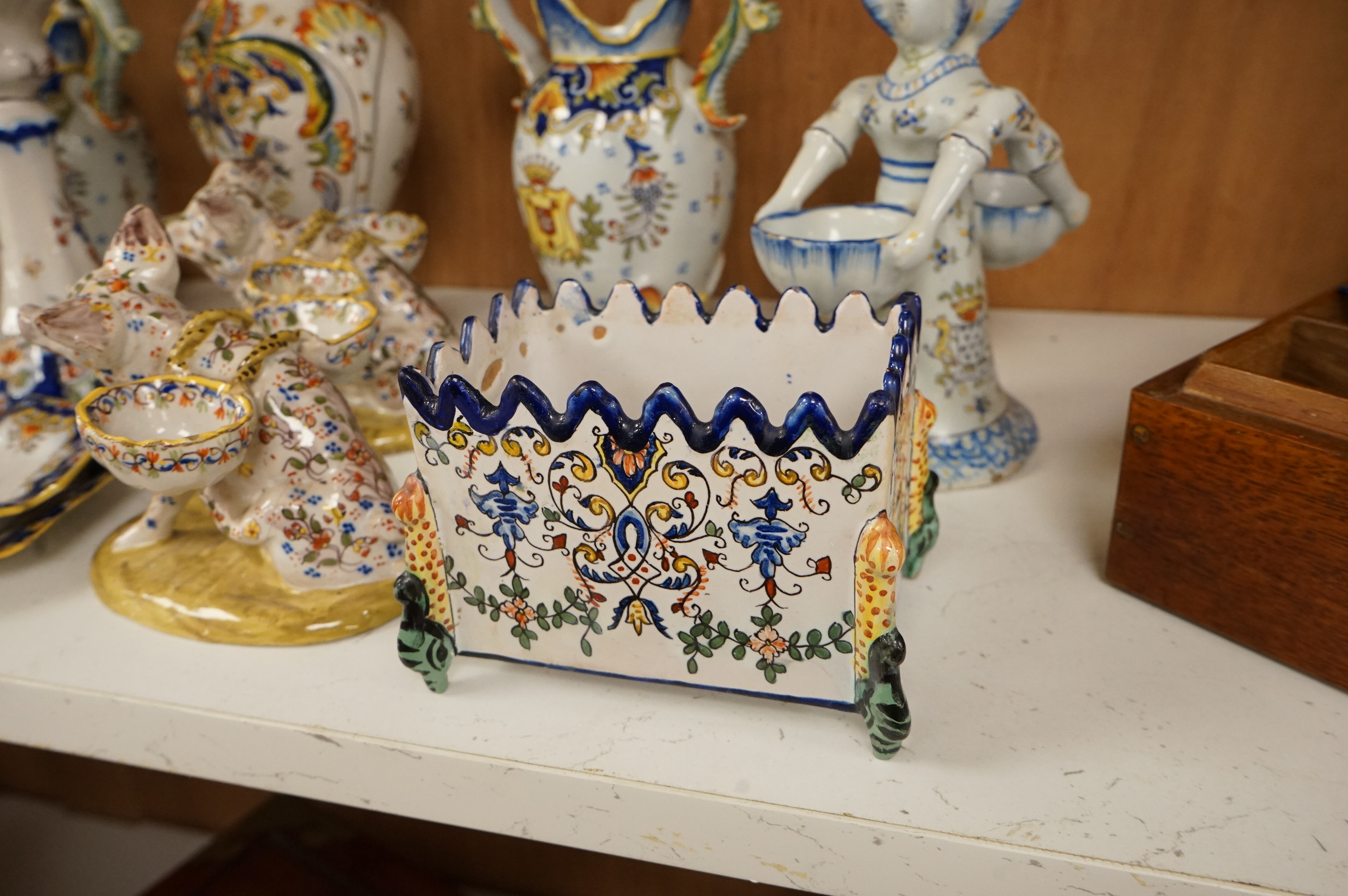 A collection of early 20th century French faience pieces to include a pair of salts in the form of pigs and candlesticks, largest 27cm high